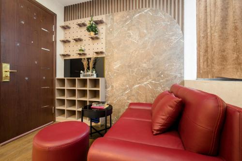 a red couch and a stool in a room at BBQ HOSTEL in Ha Long