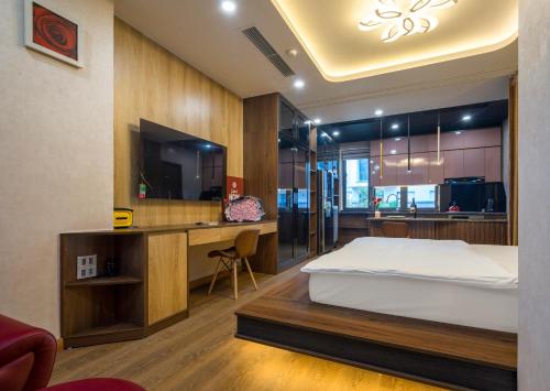 a bedroom with a bed and a desk and a television at BBQ HOSTEL in Ha Long