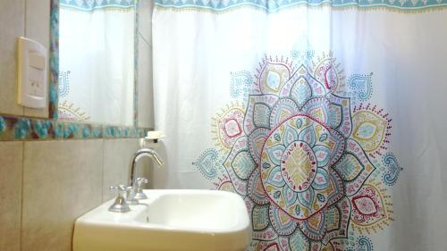 a bathroom with a sink and a shower curtain at Jazmin del Cielo in Capilla del Monte