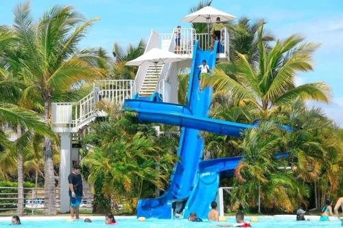 a slide at a resort with people in the water at Playa Blanca Apartamentos in Río Hato