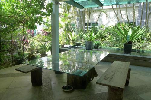 a glass table and a bench in a building at Wesberly Apartments in Kuching