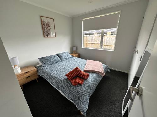 um pequeno quarto com uma cama e uma janela em Cosy Self Contained 2 Bedroom Townhouse em Hamilton