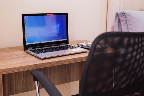 a laptop computer sitting on top of a wooden desk at Liebling Hotel Ciudad del Este in Ciudad del Este