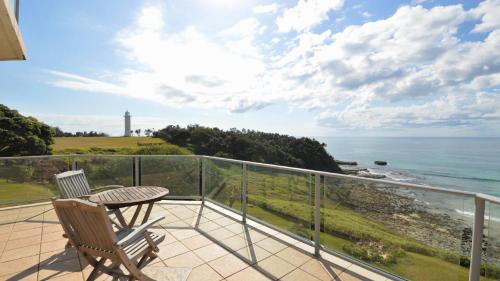 a balcony with a table and chairs and the ocean at Lonerock Unit 2 in Yamba