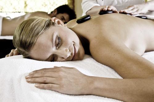 a woman laying on a bed getting a massage at Bergergut Geniesserhotel in Afiesl