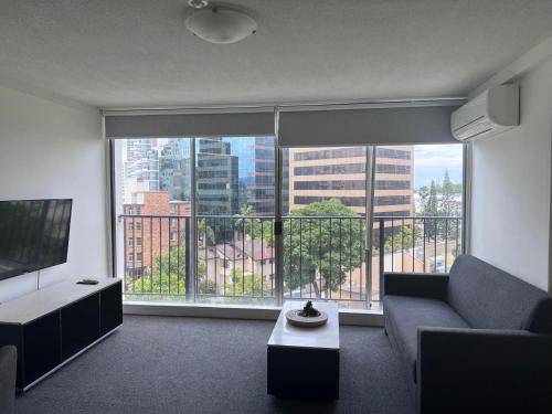 a living room filled with furniture and a window at Condor Ocean View Apartments Surfers Paradise in Gold Coast