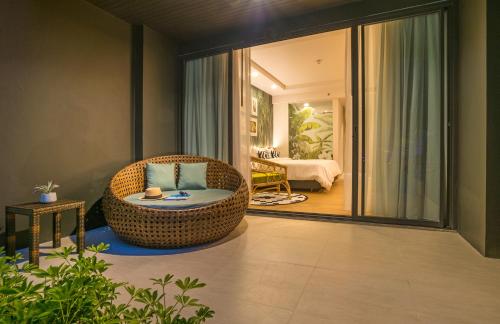 a living room with a wicker chair and a table at Panan Krabi Resort in Ao Nang Beach