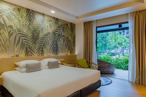 a bedroom with a bed and a large window at Panan Krabi Resort in Ao Nang Beach