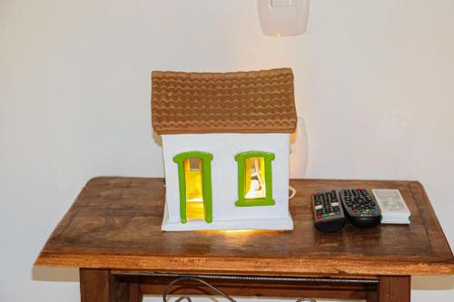 a house doll sitting on a table next to a remote control at Suites Taipe in Trancoso