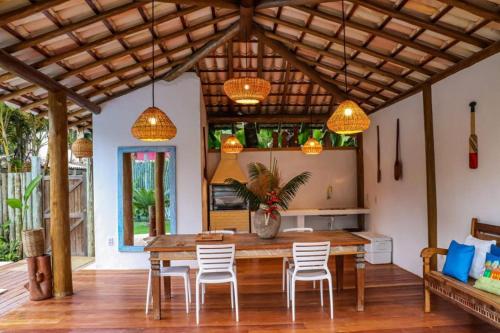 ein Esszimmer mit einem Holztisch und Stühlen in der Unterkunft Suites Taipe in Trancoso