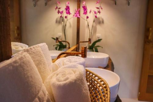 a group of towels in a bathroom with sinks at Suites Taipe in Trancoso