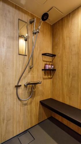 a shower in a bathroom with a sink and a mirror at 田沢湖水沢温泉郷セルリアンリゾートAoni in Senboku