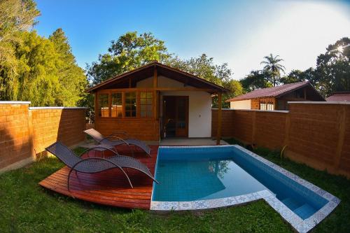 a small house with a swimming pool in the yard at Chalés da Estrada Velha in Tiradentes