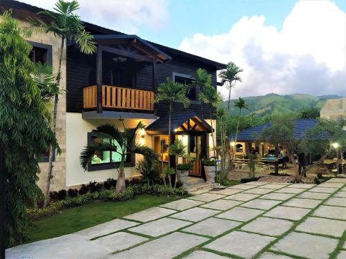 a house with a balcony and a patio at Villa Mi Patio By Hospedify - Hermosa villa con mesa de billar y río cristalino a 3 min Un pequeño paraíso en Jarabacoa in Jarabacoa