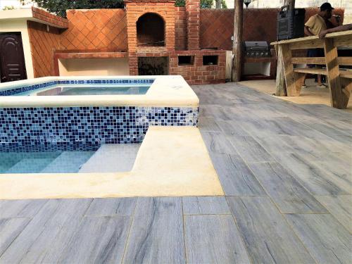 a swimming pool in a yard with a wooden deck at Villa Mi Patio By Hospedify - Hermosa villa con mesa de billar y río cristalino a 3 min Un pequeño paraíso en Jarabacoa in Jarabacoa