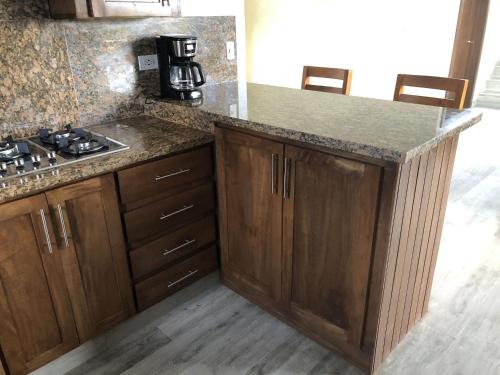 a kitchen with wooden cabinets and a counter top at Villa Mi Patio By Hospedify - Hermosa villa con mesa de billar y río cristalino a 3 min Un pequeño paraíso en Jarabacoa in Jarabacoa