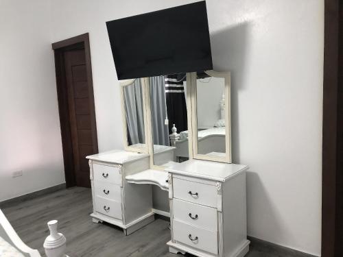 a bathroom with a white vanity and a mirror at Villa Mi Patio By Hospedify - Hermosa villa con mesa de billar y río cristalino a 3 min Un pequeño paraíso en Jarabacoa in Jarabacoa