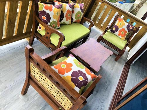 two rocking chairs with pillows on a porch at Villa Mi Patio By Hospedify - Hermosa villa con mesa de billar y río cristalino a 3 min Un pequeño paraíso en Jarabacoa in Jarabacoa