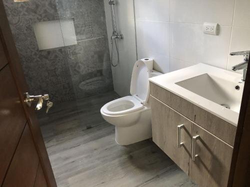 a bathroom with a toilet and a sink and a shower at Villa Mi Patio By Hospedify - Hermosa villa con mesa de billar y río cristalino a 3 min Un pequeño paraíso en Jarabacoa in Jarabacoa