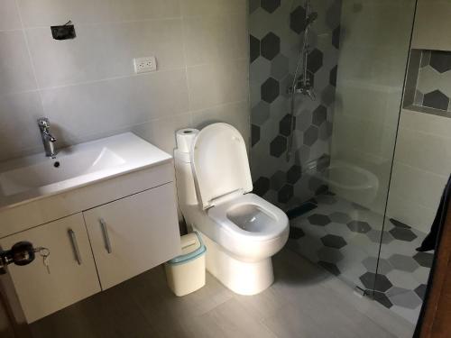 a bathroom with a toilet and a sink and a shower at Villa Mi Patio By Hospedify - Hermosa villa con mesa de billar y río cristalino a 3 min Un pequeño paraíso en Jarabacoa in Jarabacoa