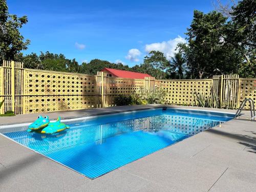 a swimming pool with a toy in front of a fence at The Cabins at LVF in Puerto Princesa City