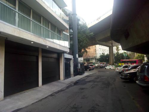 an empty street with cars parked next to a building at Recamara en Polanco (solo hombres) in Mexico City