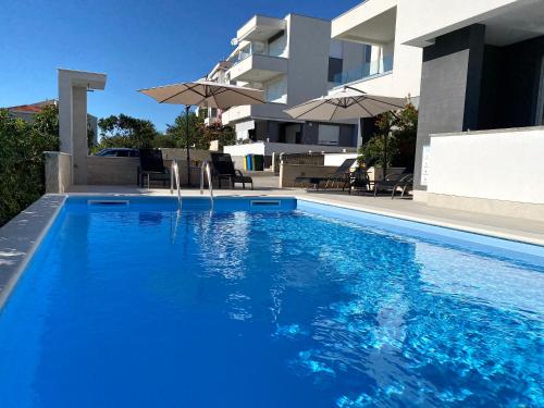 a large blue swimming pool in front of a building at Fantasy Pool Villa in Novalja