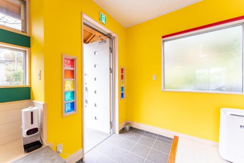 een badkamer met gele muren en een raam bij ビタミンハウス伊豆高原 - vitaminhouse IZUKOGEN in Ito
