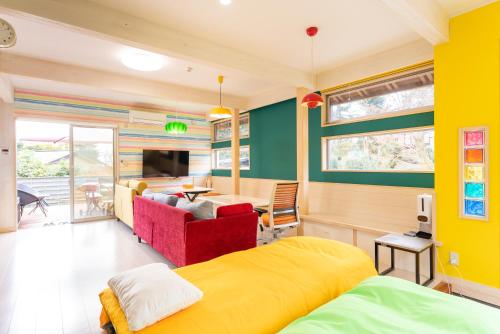 a bedroom with a yellow bed and a living room at ビタミンハウス伊豆高原 - vitaminhouse IZUKOGEN in Ito