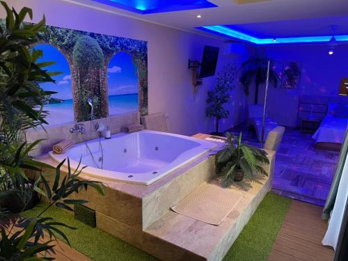 a large bath tub in a room with plants at Sosua Inn Hotel in Sosúa