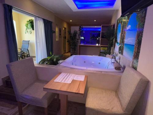 a large bathroom with a tub and a table and chairs at Sosua Inn Hotel in Sosúa