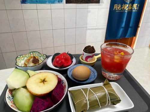 una mesa cubierta con tazones de comida y bebida en 月光祝福民宿Moonlight Blessing Hostel, en Chenggong