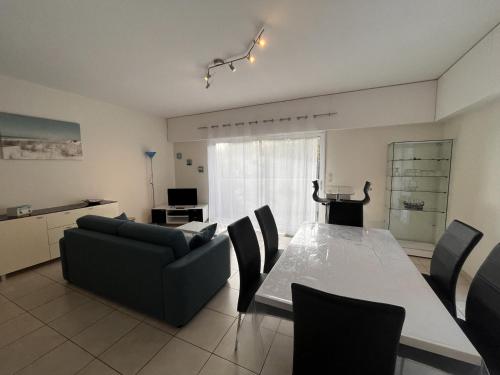 un salon avec un canapé, une table et des chaises dans l'établissement Appartement 3* près plage Les Sables-d'Olonne, 2 chambres, garage, équipements complets - FR-1-197-553, à Les Sables-dʼOlonne