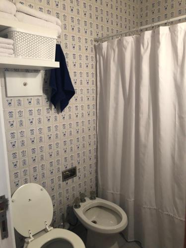 y baño con aseo y cortina de ducha. en LISBOA Departamento Premium en Mar del Plata