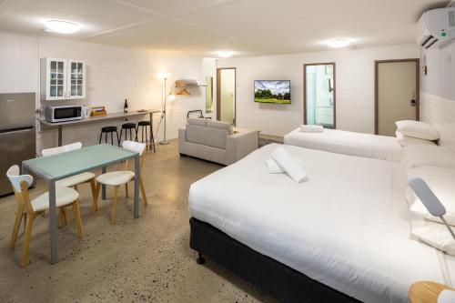 a hotel room with two beds and a table and a kitchen at 24HourCheck-In- Bridgewater Motel-Victoria-Australia in Bridgewater-on-Loddon