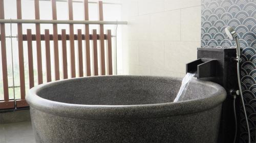 a bath tub with a water fountain in a bathroom at Da Nang - Mikazuki Japanese Resorts & Spa in Da Nang