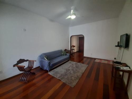 sala de estar con sofá azul y suelo de madera en Quadra Praia de Copacabana, en Río de Janeiro