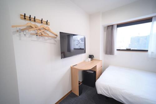 a room with a bed and a desk and a window at Ano Hotel Asakusa in Tokyo