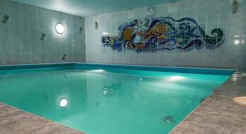 a large swimming pool with a painting on the wall at Astra in Chelyabinsk