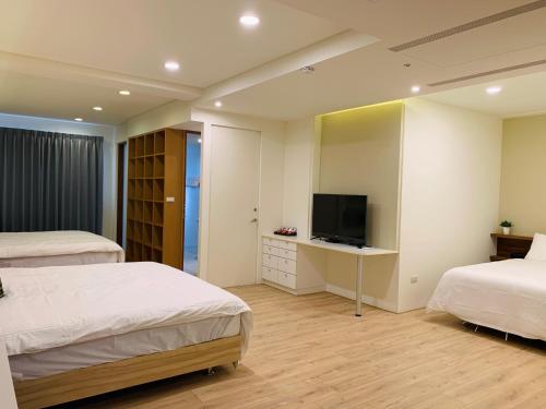a hotel room with two beds and a television at Tainan Anping - Shuiau 180 in Tainan