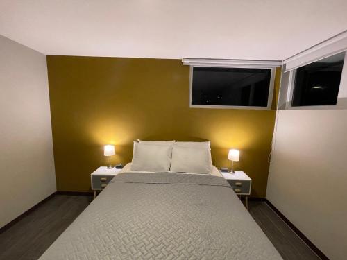 a bedroom with a large bed with two lamps on it at Hotel Villas Santander in Guatemala