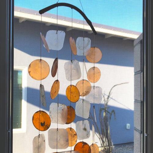 a bunch of shells hanging from a window at Whistling Cloud/ Design+Desert Views+National Park in Joshua Tree