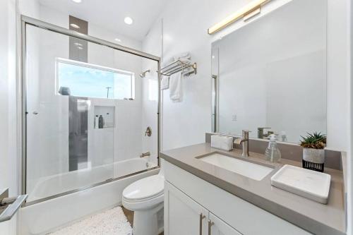 a white bathroom with a sink and a toilet at Whistling Cloud/ Design+Desert Views+National Park in Joshua Tree