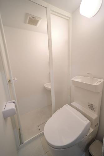 a white bathroom with a toilet and a shower at Ano Hotel Asakusa in Tokyo