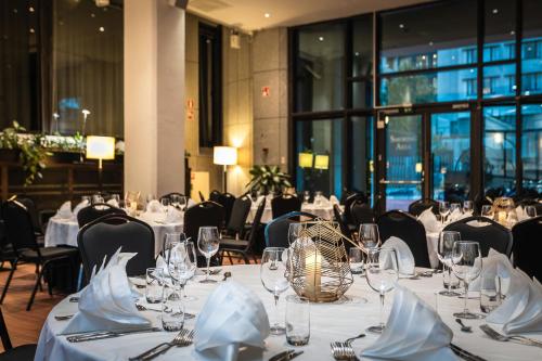 a dining room with tables with white tablecloths and glasses at Crowne Plaza Helsinki - Hesperia by IHG in Helsinki