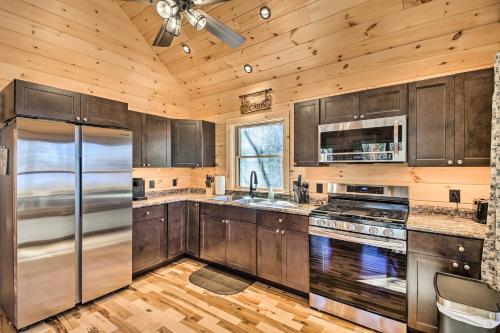 a kitchen with wooden cabinets and a stainless steel refrigerator at Inviting Webb Lake Cabin with Mountain Views 