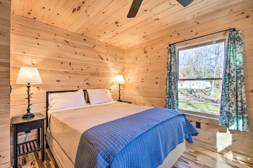 um quarto com uma cama e uma janela num chalé de madeira em Inviting Webb Lake Cabin with Mountain Views 