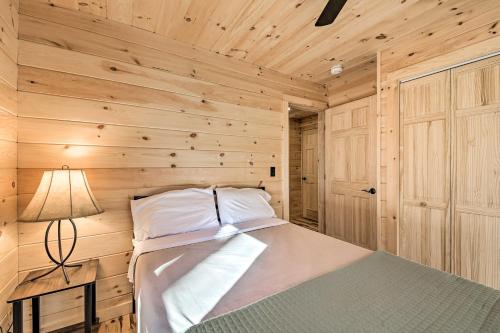 a bedroom with a bed in a wooden wall at Inviting Webb Lake Cabin with Mountain Views in Weld