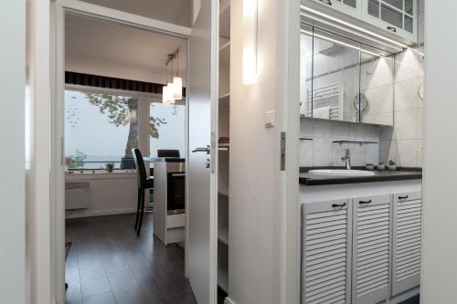 una cocina con armarios blancos y una mesa con fregadero en Am Hang 15 Seeblick App 7 en Scharbeutz