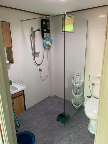 La salle de bains est pourvue d'une douche et de toilettes. dans l'établissement Lampang Hideaway Guesthouse, à Lampang